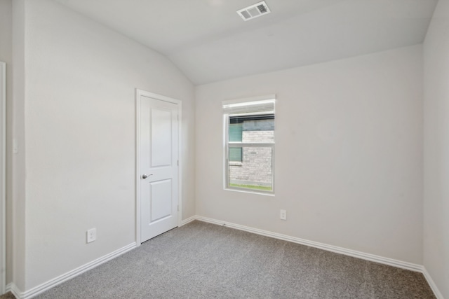 spare room featuring carpet and lofted ceiling