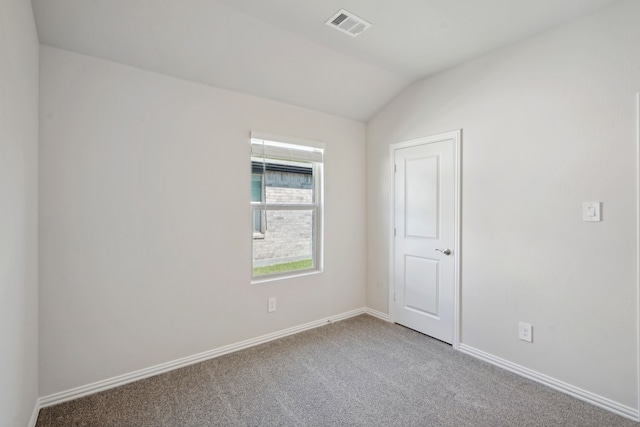 empty room with carpet and vaulted ceiling