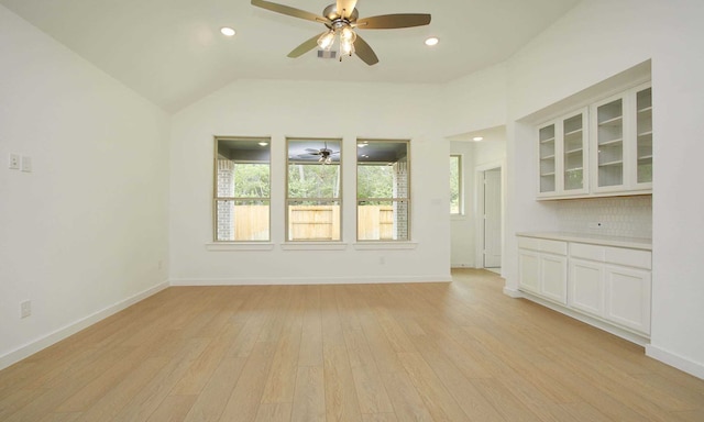 unfurnished living room featuring light hardwood / wood-style flooring, a healthy amount of sunlight, and vaulted ceiling