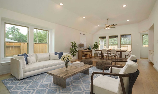 living room with light wood-type flooring, vaulted ceiling, and ceiling fan