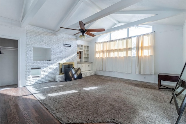 unfurnished living room featuring hardwood / wood-style floors, vaulted ceiling with beams, a brick fireplace, and ceiling fan