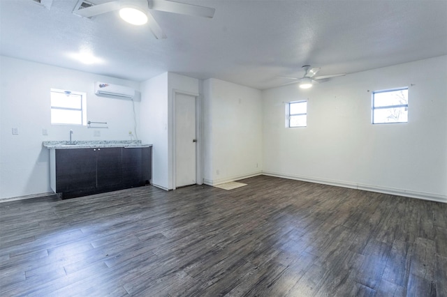 interior space featuring an AC wall unit, ceiling fan, and dark wood-type flooring