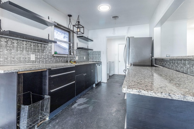 kitchen featuring light stone counters, sink, stainless steel appliances, and tasteful backsplash