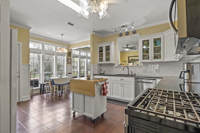 kitchen with sink, stainless steel dishwasher, dark tile patterned floors, tasteful backsplash, and white cabinetry