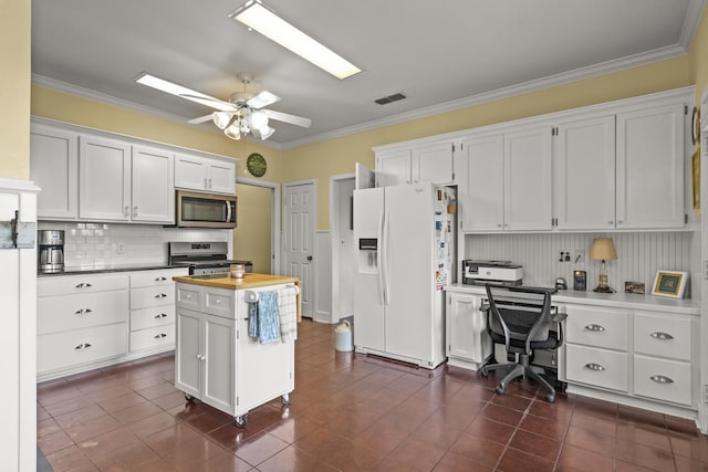 kitchen featuring ornamental molding, appliances with stainless steel finishes, and white cabinets