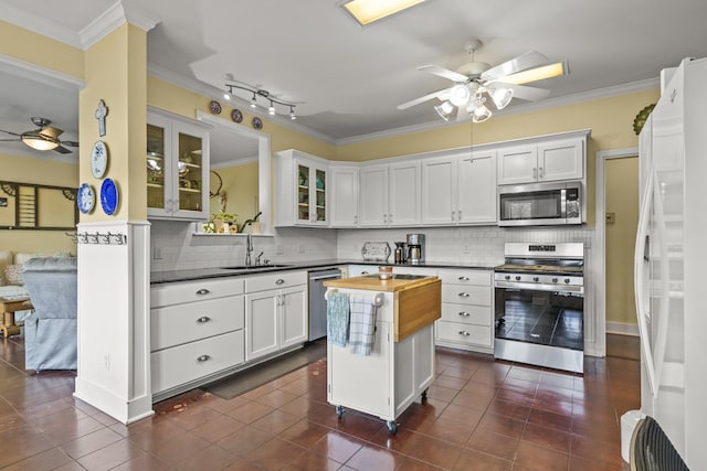 kitchen with white cabinetry, wood counters, ornamental molding, and appliances with stainless steel finishes