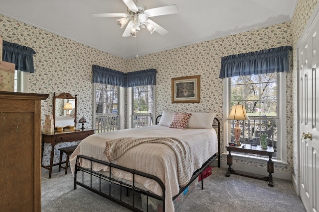 carpeted bedroom with ceiling fan, crown molding, and multiple windows