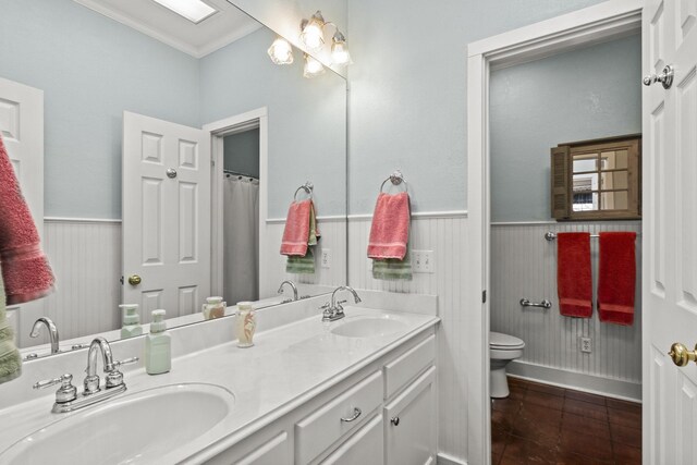 bathroom featuring toilet, vanity, tile patterned floors, and crown molding