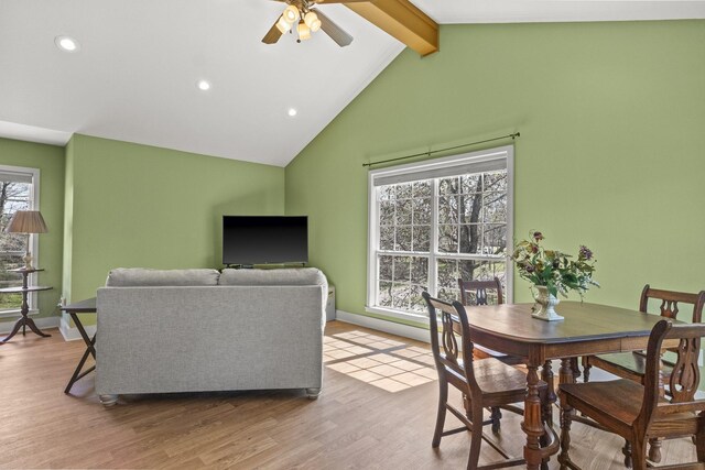 dining space with hardwood / wood-style floors, vaulted ceiling with beams, plenty of natural light, and ceiling fan