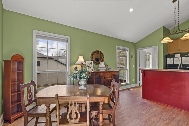 dining room featuring wood-type flooring and lofted ceiling