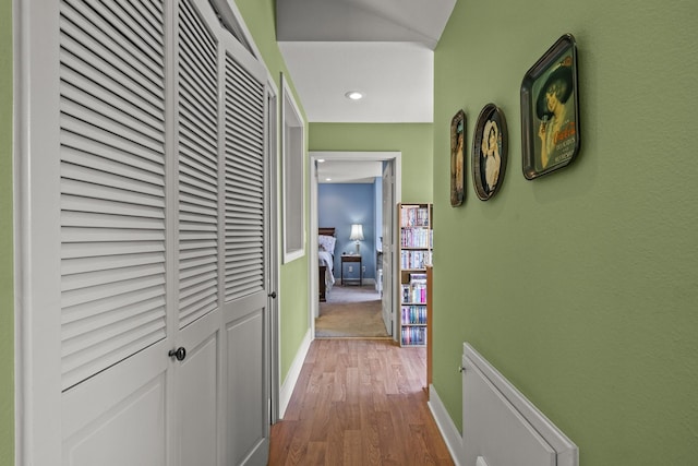 corridor featuring light hardwood / wood-style floors and lofted ceiling