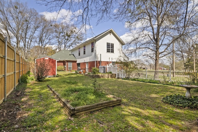 rear view of house featuring cooling unit, a shed, and a yard