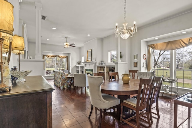 dining space featuring dark tile patterned flooring, ceiling fan with notable chandelier, a healthy amount of sunlight, and ornamental molding