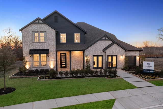 view of front of house with a garage and a lawn