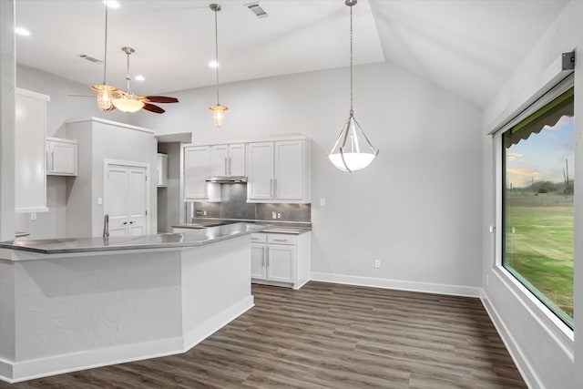 kitchen with dark wood-style floors, lofted ceiling, visible vents, decorative backsplash, and white cabinetry