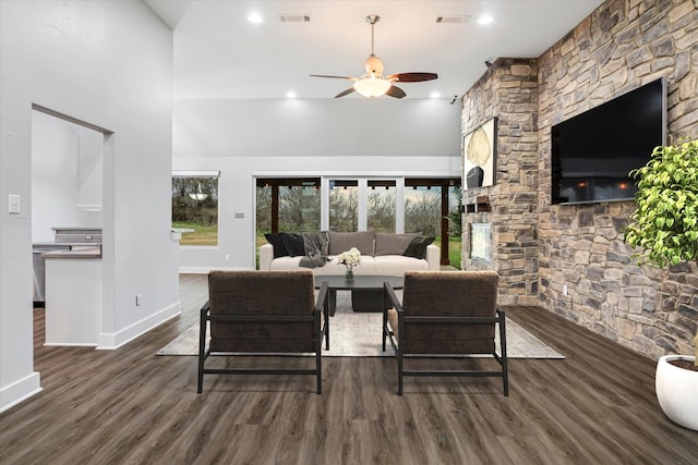 living area with a ceiling fan, visible vents, baseboards, and wood finished floors