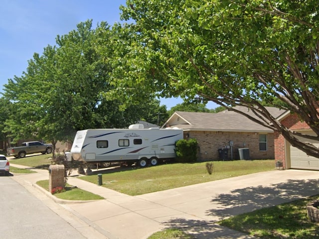 view of front of home with a front yard and central AC