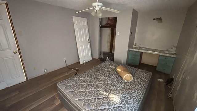 bedroom featuring dark hardwood / wood-style flooring, built in desk, and ceiling fan