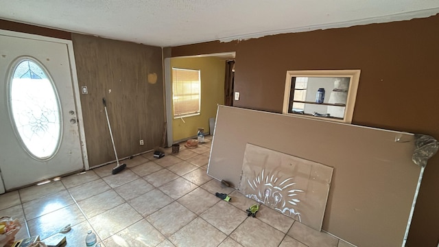 entrance foyer with light tile patterned floors and a textured ceiling