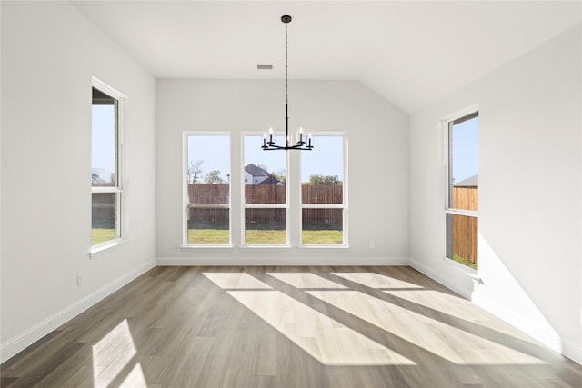 unfurnished dining area featuring hardwood / wood-style flooring, plenty of natural light, and an inviting chandelier