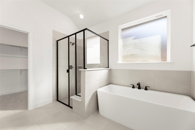 bathroom with tile patterned flooring, shower with separate bathtub, vaulted ceiling, and a wealth of natural light