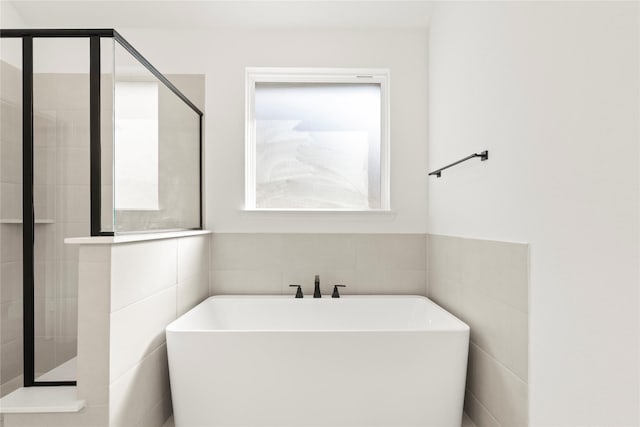 bathroom with a healthy amount of sunlight and independent shower and bath