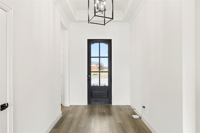 entryway with hardwood / wood-style floors, crown molding, and an inviting chandelier