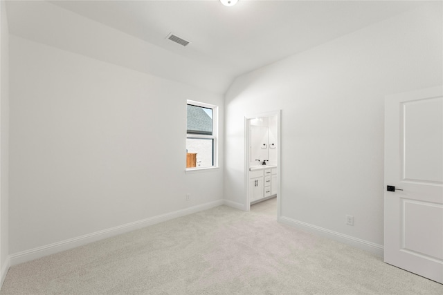 carpeted empty room with lofted ceiling