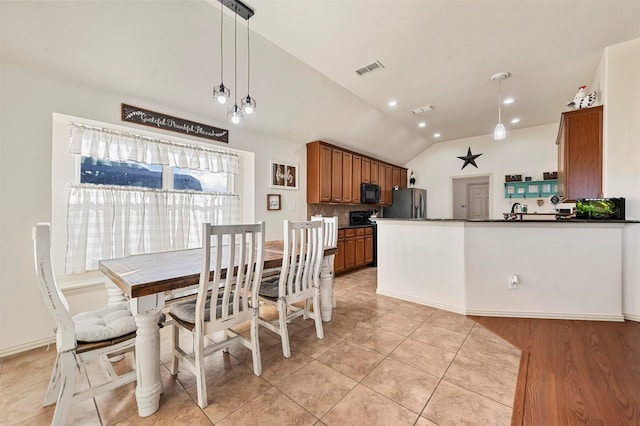 dining space featuring lofted ceiling and light tile patterned floors