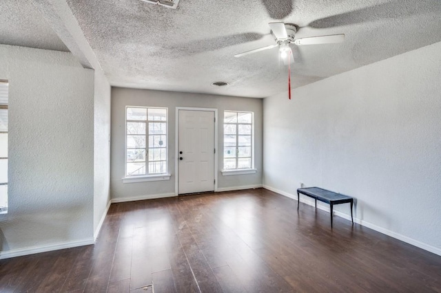 entryway with ceiling fan, dark wood-type flooring, and a textured ceiling