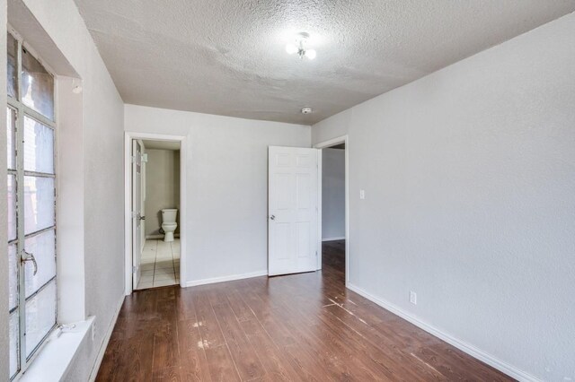 unfurnished room featuring a textured ceiling and dark wood-type flooring