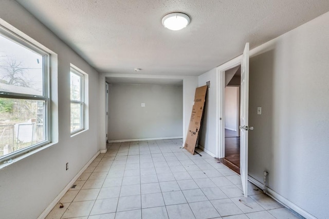 tiled spare room with a textured ceiling