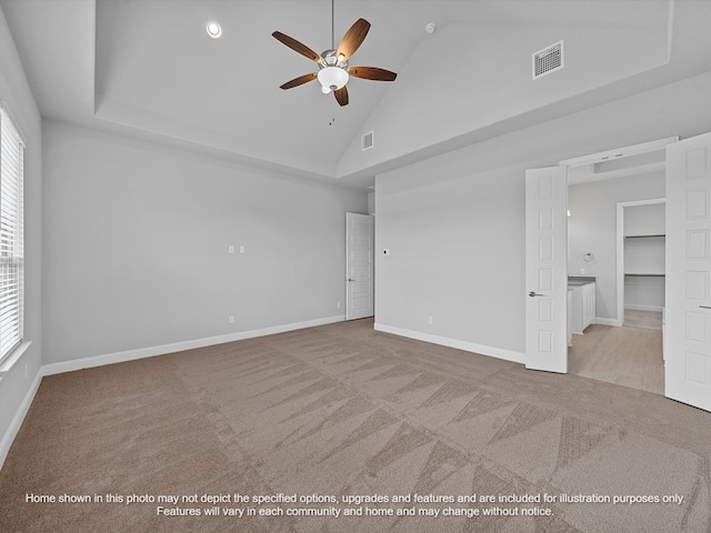 carpeted empty room with ceiling fan, a wealth of natural light, and high vaulted ceiling