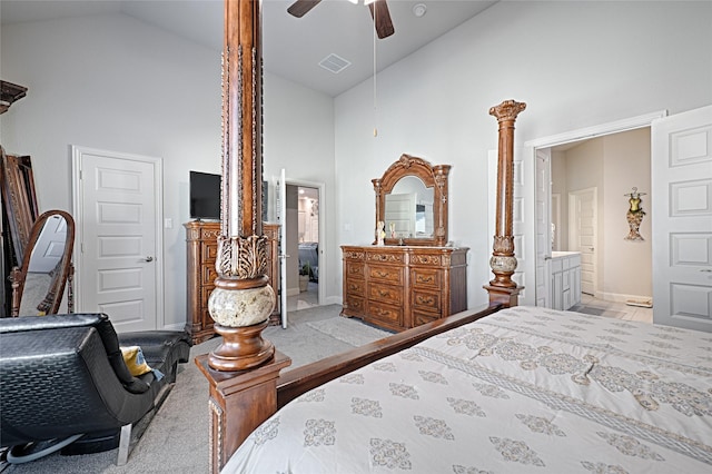 carpeted bedroom with ensuite bathroom, ceiling fan, and high vaulted ceiling