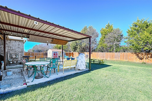 view of yard featuring a patio, an outbuilding, a fenced backyard, and a storage unit