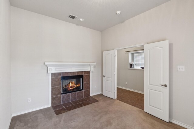 unfurnished living room with carpet flooring and a fireplace