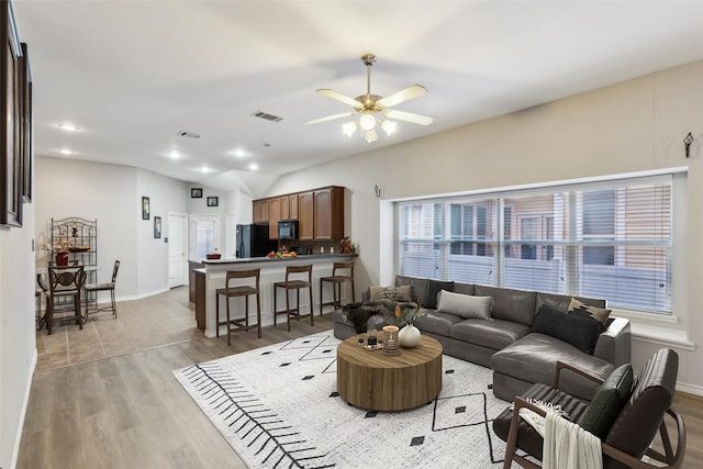 living room featuring ceiling fan and light hardwood / wood-style flooring