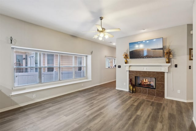 unfurnished living room featuring a tile fireplace, wood-type flooring, and ceiling fan