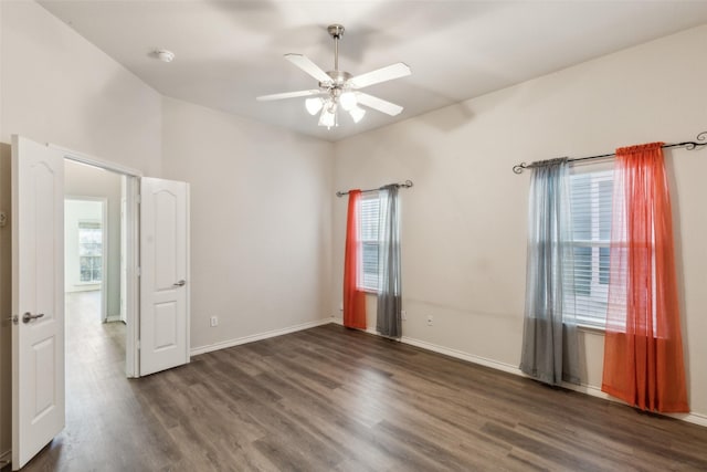 unfurnished room with ceiling fan and dark wood-type flooring