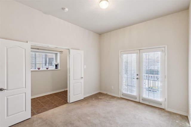 empty room with light carpet, a wealth of natural light, and french doors