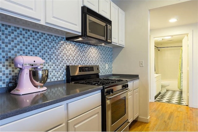 kitchen featuring tasteful backsplash, white cabinetry, and stainless steel gas range