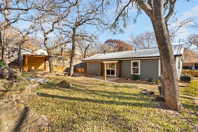 back of house with a lawn and central air condition unit