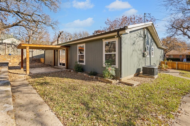 view of home's exterior with central AC and a lawn