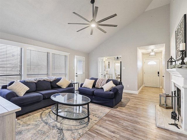 living room with light hardwood / wood-style floors, high vaulted ceiling, and ceiling fan