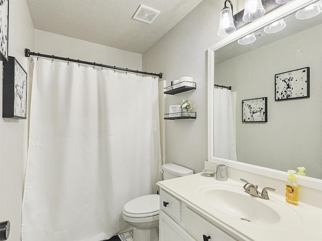 bathroom featuring vanity, toilet, and a textured ceiling