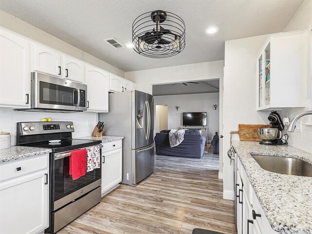 kitchen with ceiling fan, white cabinetry, sink, and appliances with stainless steel finishes