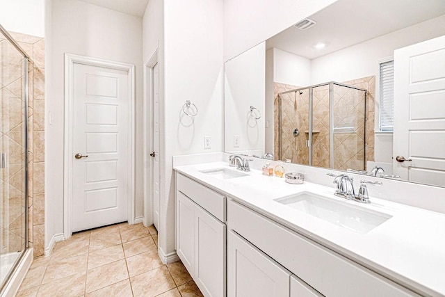 bathroom with vanity, tile patterned floors, and a shower with door