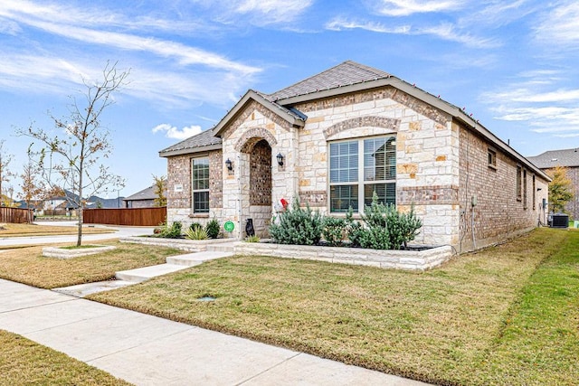 view of front of property featuring a front yard and central AC unit