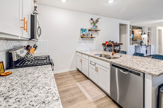 kitchen with light stone counters, white cabinetry, sink, and appliances with stainless steel finishes