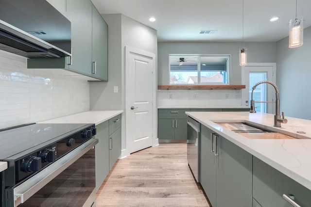 kitchen with decorative backsplash, appliances with stainless steel finishes, light stone counters, sink, and exhaust hood